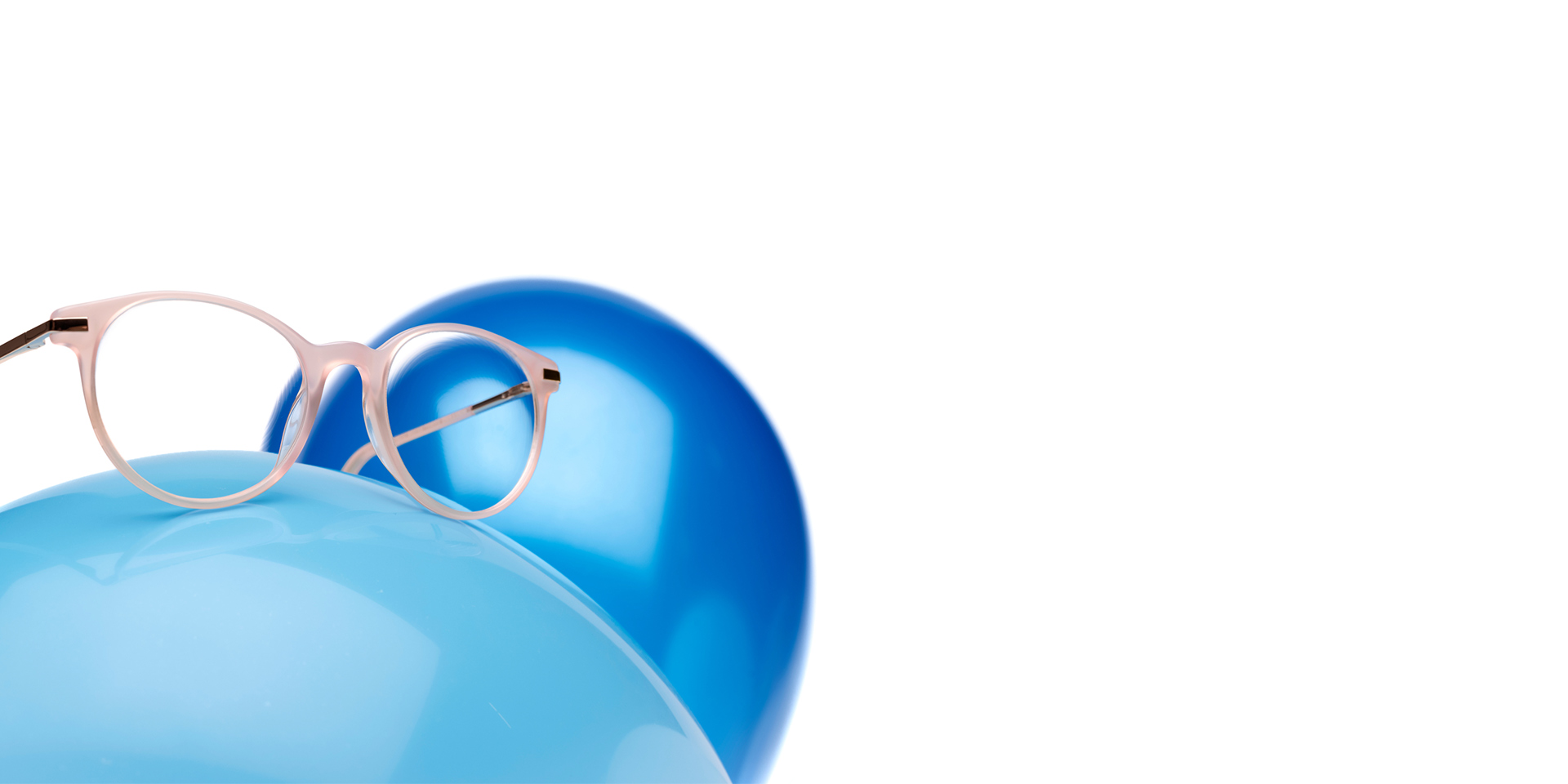 Bej pembemsi çerçeveli ZEISS MyoCare gözlük camları açık mavi bir balon üzerinde gösteriliyor. Arka planda biraz daha koyu mavi bir balon daha var.