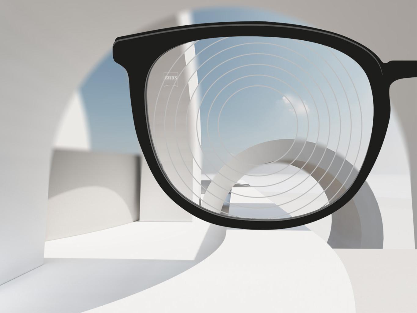 Siyah gözlüklü ZEISS miyop yönetimi gözlük camlarının yakın çekim görüntüsü ve gözlük camı yüzeyinde eş merkezli daireler.