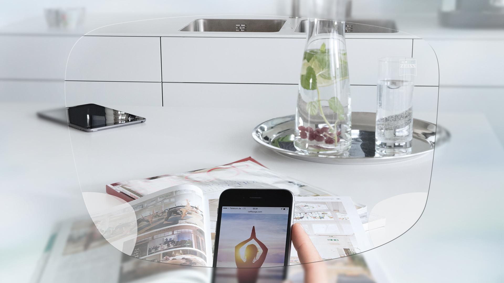 Akıllı telefon ekranında ve düzenli mutfak masasında ZEISS EnergizeMe Tek Odaklı Gözlük Camı ile görüntüleyin