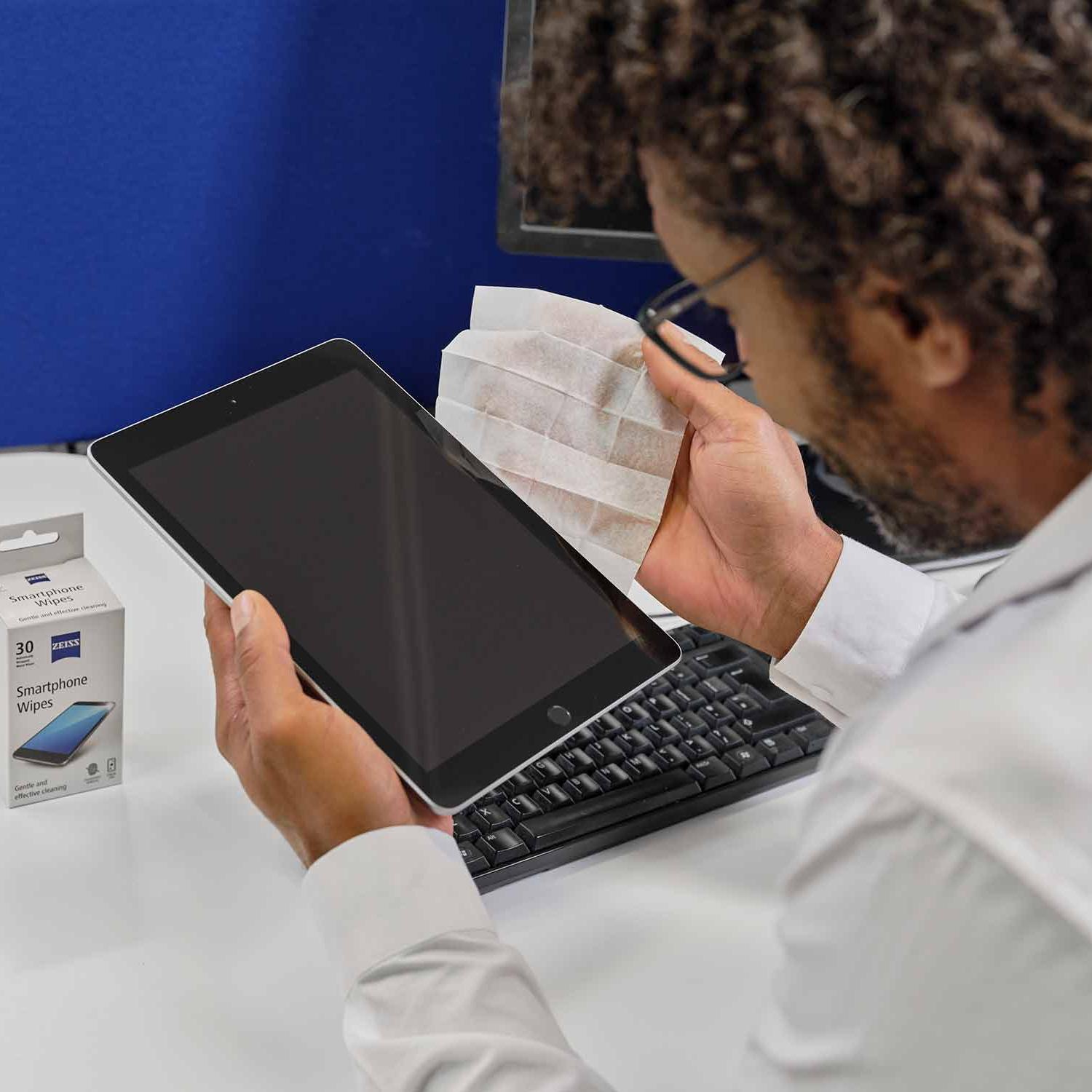 Adam akıllı telefon mendilleriyle tablet ekranını temizliyor