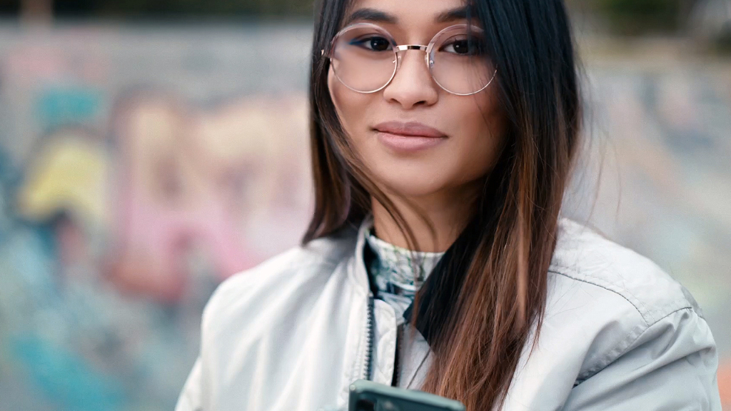 Kaykay parkında ZEISS Single Vision SmartLife camları takan genç bir kadın.